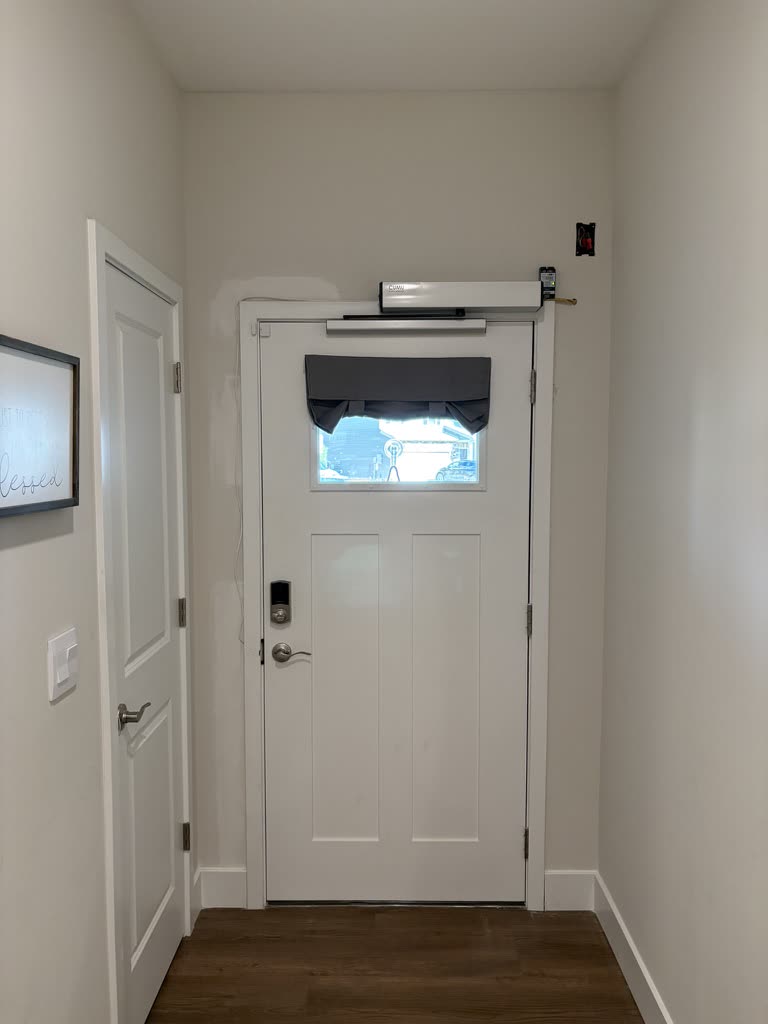 Automatic door opener installed above a white residential entry door.